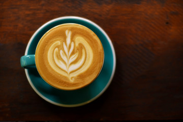 ็High angle view, Coffee latte art on wooden table.