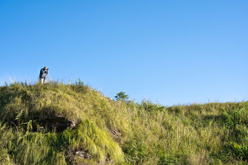 A photographer man backpacker hand holding the camera and shooting a picture to the beautiful scenic mountain view.Happy Vacation holiday outdoor scene landscape.Travel Freedom concept.