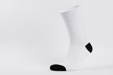 Blank white cotton long sock with black heel on invisible foot on white background as mock up for...