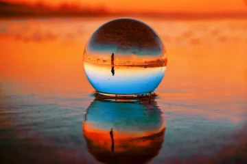 Zelfklevend Fotobehang Beautiful selective focus shot of a crystal ball reflecting the breathtaking sunset © Nicole Avagliano/Wirestock