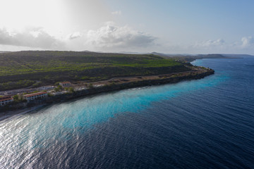 Aerial view of coast of Curaçao in the Caribbean Sea with turquoise water, cliff, beach and beautiful coral reef around Sta. Martha Bay