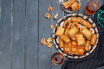 Top view of big metal tray with turkish baklava on planked wooden table