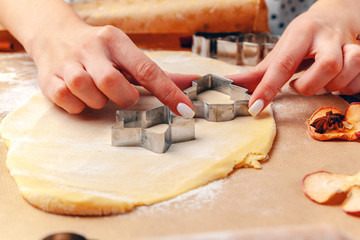  female hands making cookies from fresh dough at home