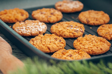 Top view of oat cookies in baking tray on wooden table