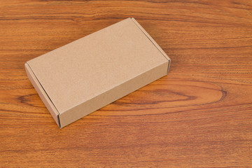 Empty brown cardboard box or tray for mock up on the wooden table with copy space.