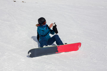 Girl snowboarder takes pictures.
