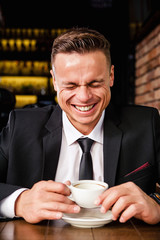 Angry businessman drinks coffee