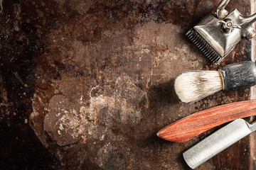 hairdressing scissors vintage manual clipper comb brush dangerous razor are on a on a rusty old beautiful surface.