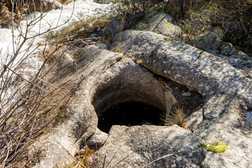 Circular shapes created in granite rock by erosion of river water in La Pedriza, Madrid