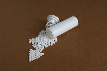 White plastic vials with pills on brown cardboard backgound