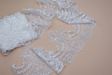 Texture lace fabric. lace on white background studio. thin fabric made of yarn or thread. a background image of ivory-colored lace cloth. White lace on beige background.