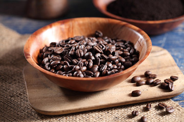 Coffee beans in wooden cup on rustic wooden table with a blank space for a text, Coffee in cup on loft background