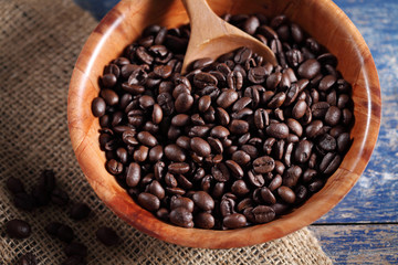 Coffee beans in wooden cup on rustic wooden table with a blank space for a text, Coffee in cup on loft background
