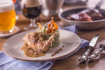 Rabbit leg with mashes potatoes and decoration on plate in restaurant