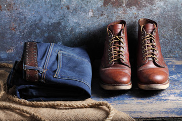 Old blue jeans and safety shoes on rustic background, Old blue jeans and safety shoes in a store