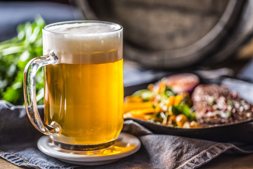 Glass of light beer in pub or restavurant on table with delicoius food