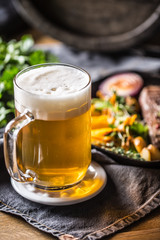 Glass of light beer in pub or restavurant on table with delicoius food