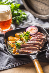 Beef flank steak in grill pan with batata puree garlic herb decoration and draft beer