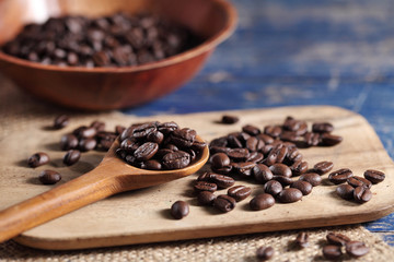 Obraz premium Coffee beans in wooden spoon on rustic wooden table with a blank space for a text, Coffee in cup on loft background