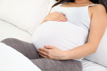Pregnant woman in bed at home, closeup