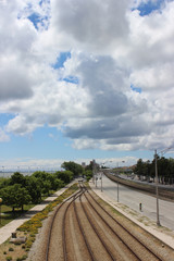 the railway goes into the distance, huge clouds