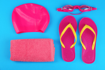 Flat lay composition with swimming accessories on light blue background