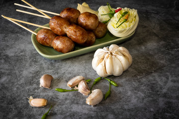 Thai sausage with fresh vegetables and peppers on a concrete background
