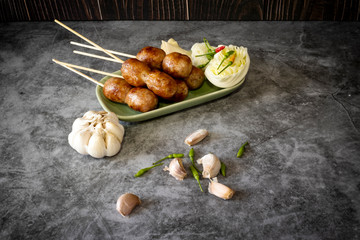 Thai sausage with fresh vegetables and peppers on a concrete background