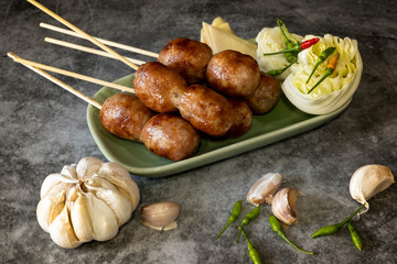 Thai sausage with fresh vegetables and peppers on a concrete background