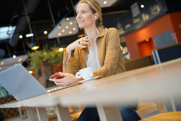 young businesswoman on the phone in a cafeteria