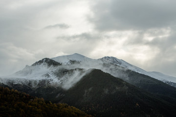 El pico de una montaña nevada con nubes. 