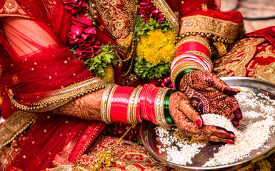 Indian Hindu Bride wearing beautiful Red Lehenga in her marriage, and performing traditional ritual...