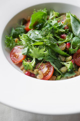 Homemade green broccoli salad with grapes, onion and tomato