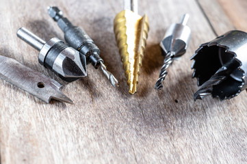 Variety of different types of bit drill displyed on old wooden background. Selective focus.