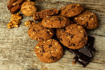 Homemade chocolate cookies with nuts on wooden table. Sweet food for coffee. Unhealthy food. Risk of obesity.