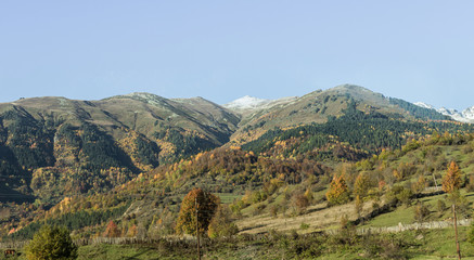 Naklejka premium Panoramic view of mountains and peaks in the snow, visible in the distance, in the mountainous part of Georgia - Svaneti at sunset