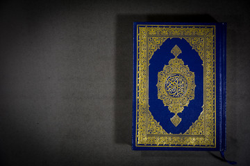 Top angle view of Muslims Holy Book Quran Majid on a black background