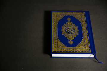 Top angle view of Muslims Holy Book Quran Majid on a black background