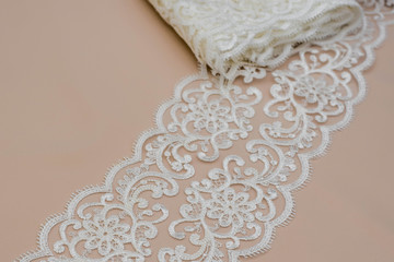 Texture lace fabric. lace on white background studio. thin fabric made of yarn or thread. a background image of ivory-colored lace cloth. White lace on beige background.