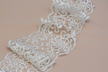 Texture lace fabric. lace on white background studio. thin fabric made of yarn or thread. a background image of ivory-colored lace cloth. White lace on beige background.