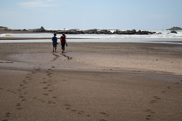 couple on the beach leaving footprints behind