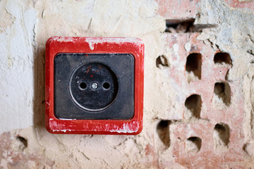 EU power outlet type C, electric point of power at home, on a red brick background with holes