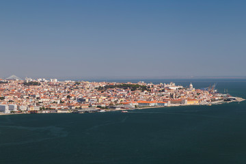 Fototapeta na wymiar City of Lisbon and Tagus River in Portugal viewed slightly from above on a sunny day in the summer.