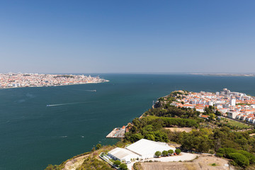 Fototapeta na wymiar Lisbon and Almada cities and Tagus River in between in Portugal viewed from above on a sunny day in the summer.