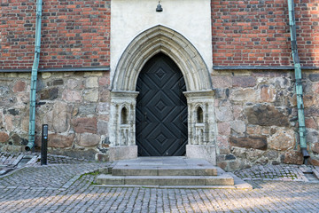 Medieval black wooden door. Turku, Finland - July 2017.