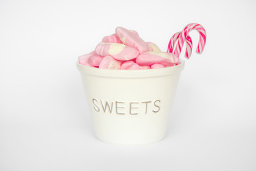 Marshmallows in a white bowl on a white background.