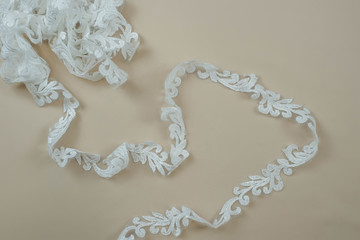 Texture lace fabric. lace on white background studio. thin fabric made of yarn or thread. a background image of ivory-colored lace cloth. White lace on beige background.