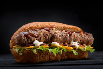 close up of kebab sandwich on black wooden background