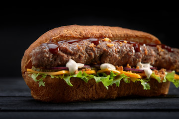 close up of kebab sandwich on black wooden background