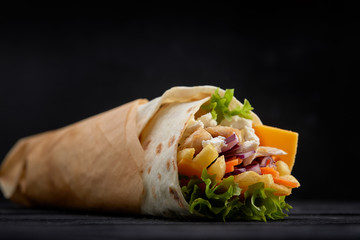 Tasty doner kebabs with fresh salad trimmings and shaved roasted meat served in tortilla wraps on...